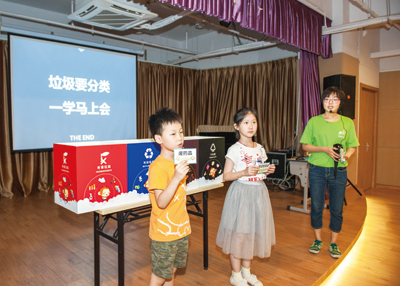 8月22日，倪佳洁老师在彭浦镇爱心暑托点宣讲垃圾分类，图为小朋友们玩起了扔垃圾的互动游戏（孙卉摄）.jpg